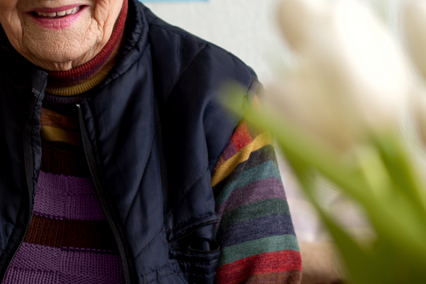 Image description: an obscured photograph of an older woman smiling.